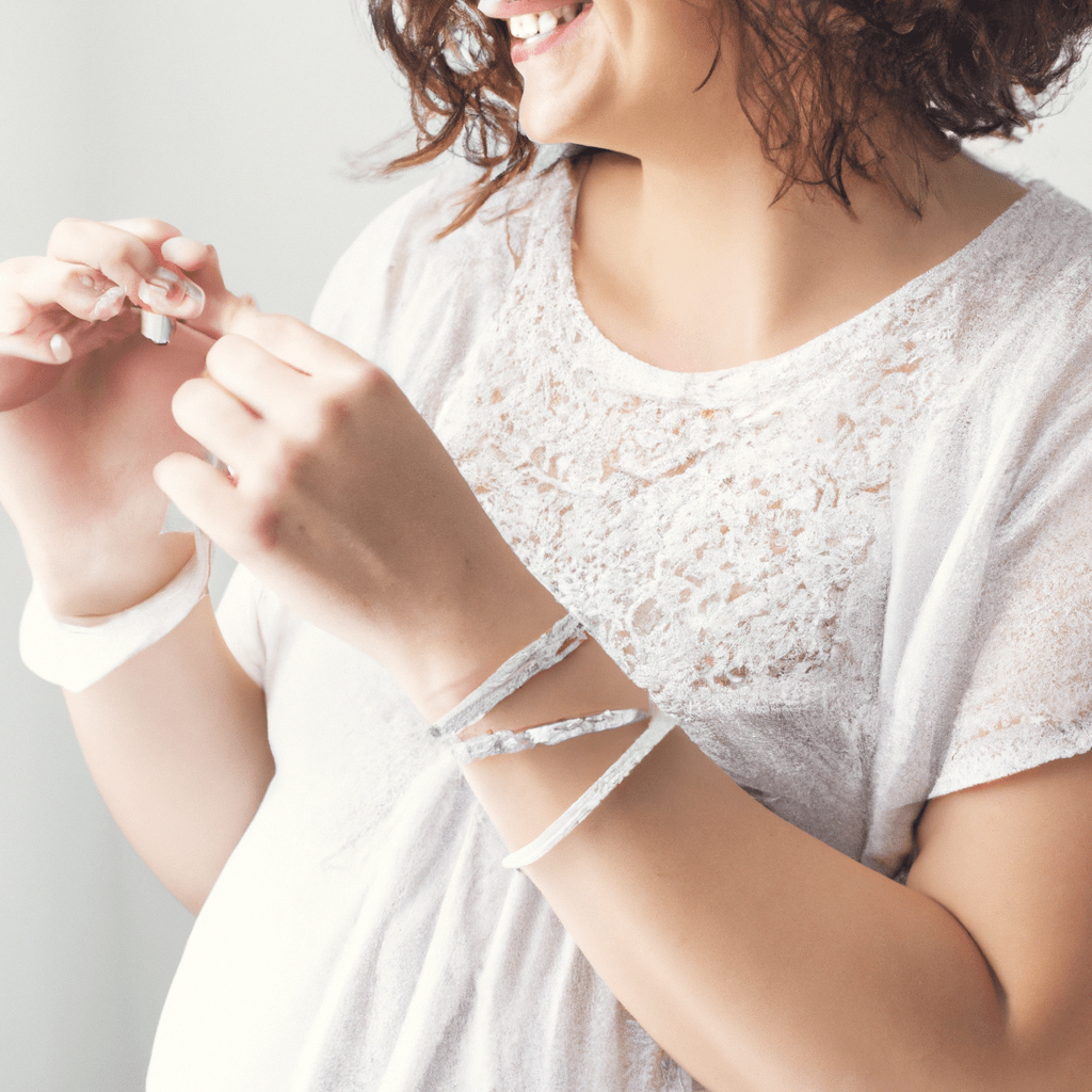 A pregnant woman smiling as she adorns her trendy maternity outfit with a delicate bracelet, adding a touch of elegance to her pregnancy style. Sigma 85 mm f/1.4. No text.. Sigma 85 mm f/1.4. No text.